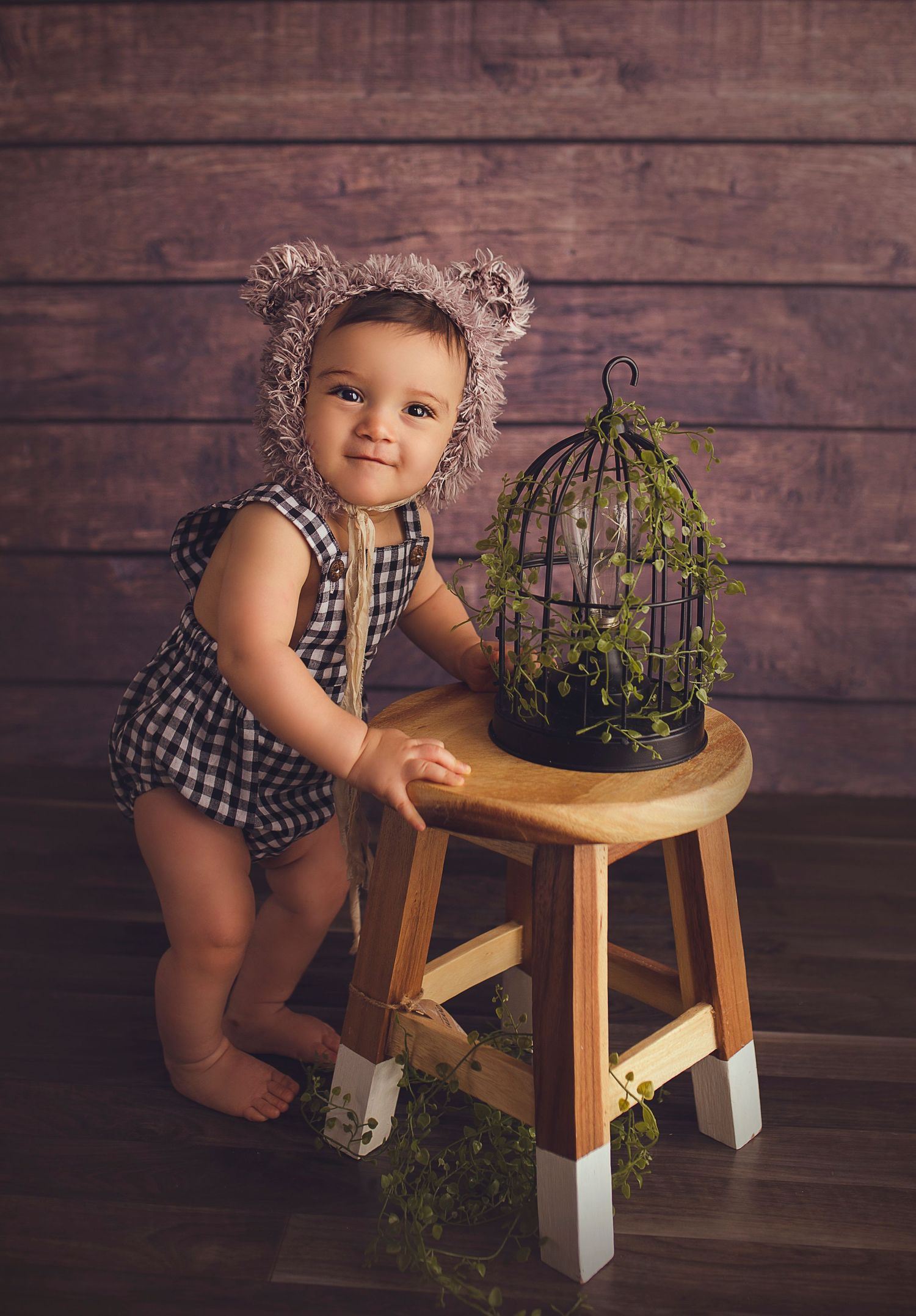 baby boy in wood set up with bear bonnet