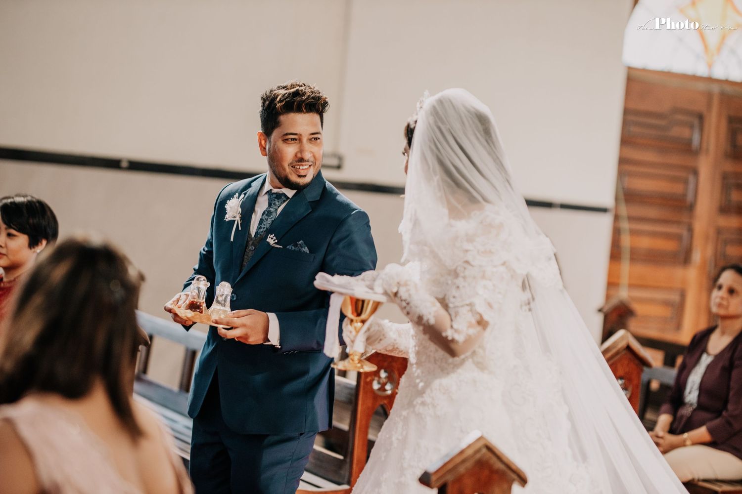 Traditional church wedding ceremony with decorative floral arrangements and gathered guests.