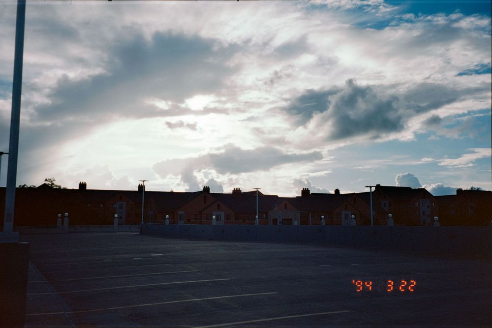 Row of buildings with dramatic cloudy sky during sunset.