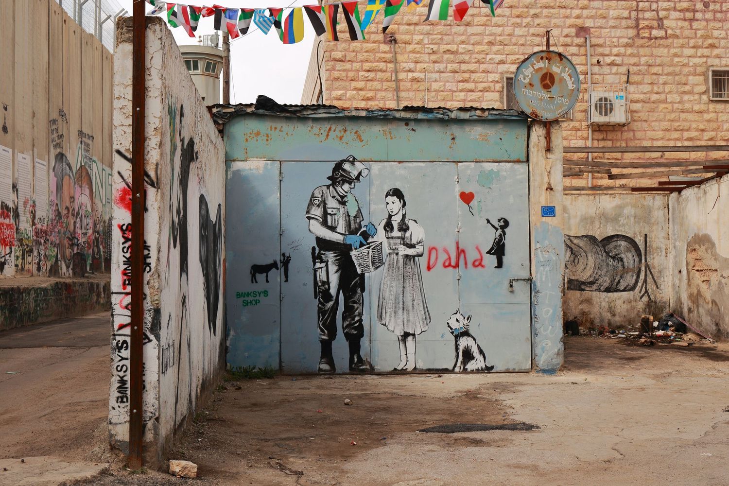 Urban street art on a metal door shows stenciled figures in black and white.