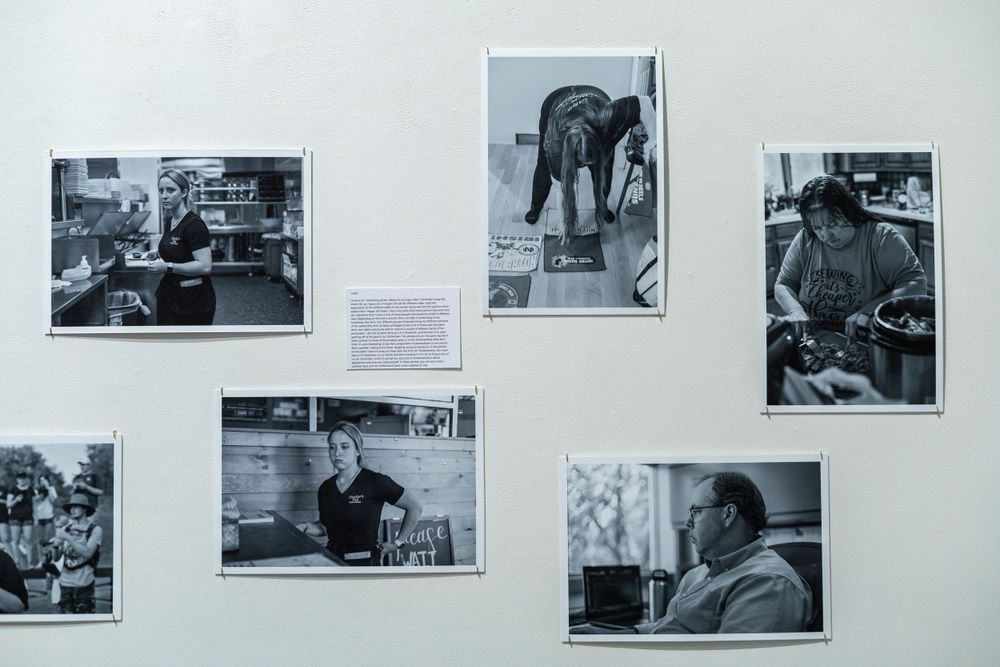 Collection of black and white documentary photographs arranged on a gallery wall.