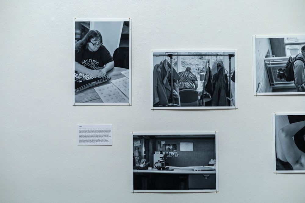 Series of black and white documentary photographs mounted on a gallery wall with descriptive text.