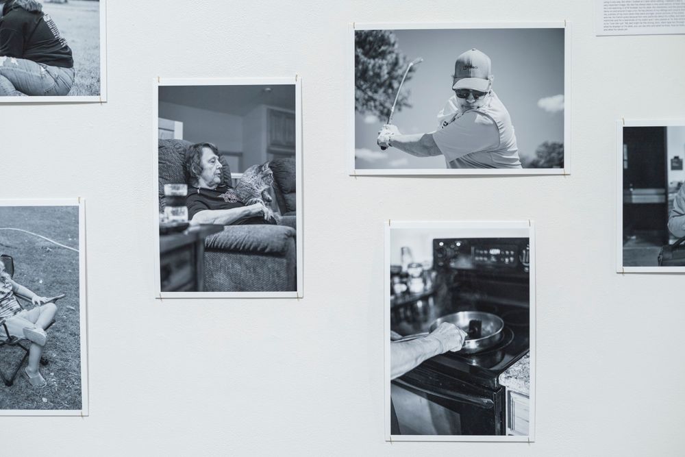 Collection of nostalgic black and white photographs arranged on a gallery wall.
