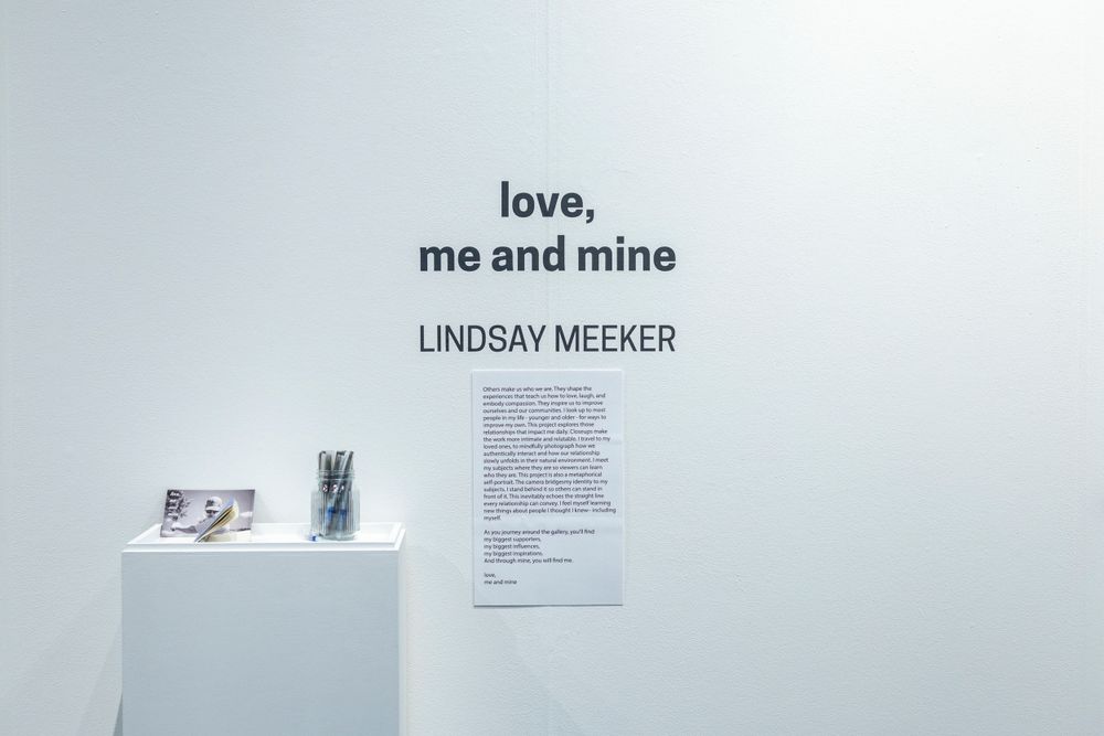 White gallery walls displaying black and white photographs in a minimalist exhibition space.