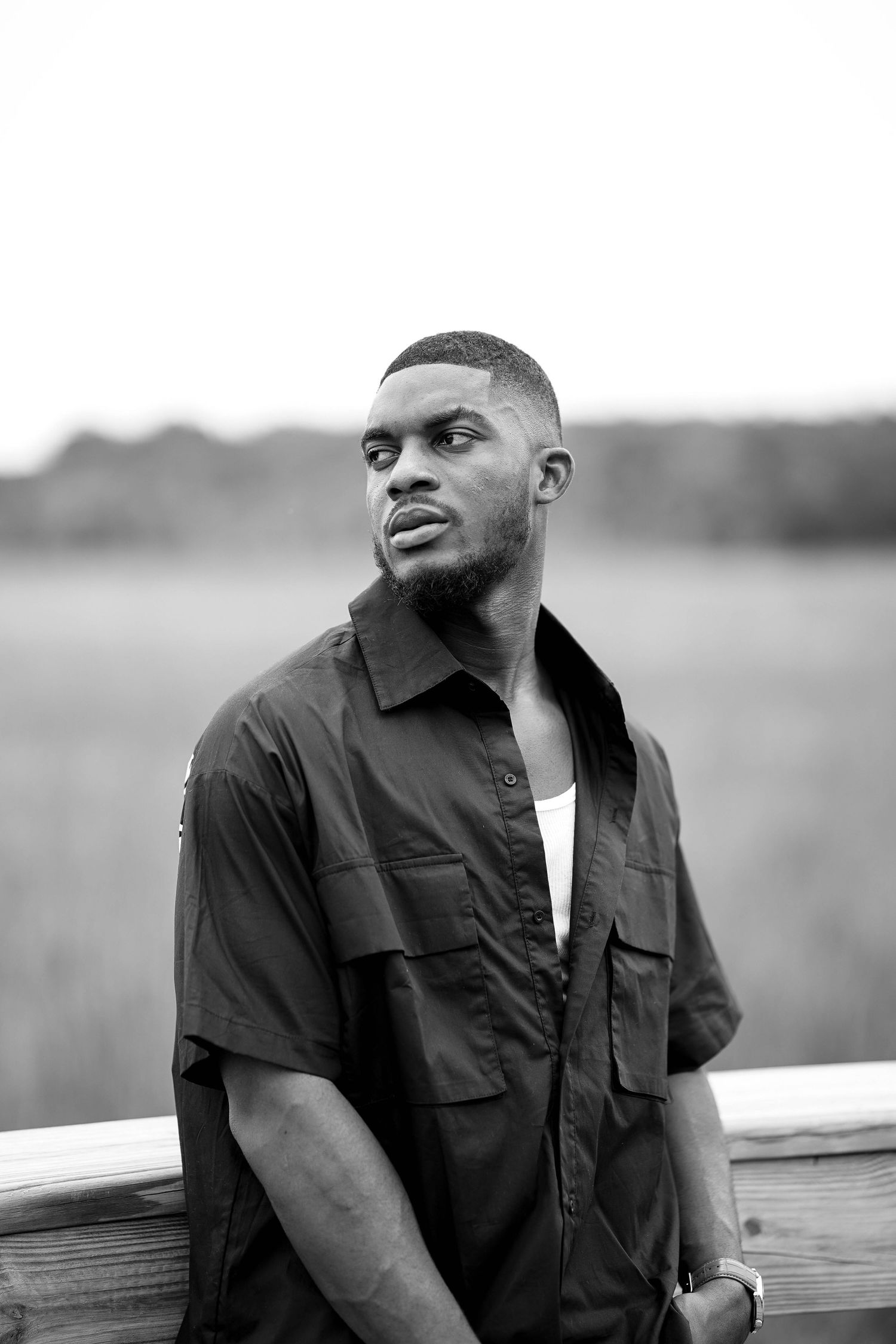 Black and white series of outdoor portraits leaning on wooden railing.