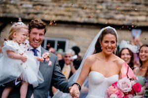 Wedding celebration with confetti flying through the air on a sunny afternoon.