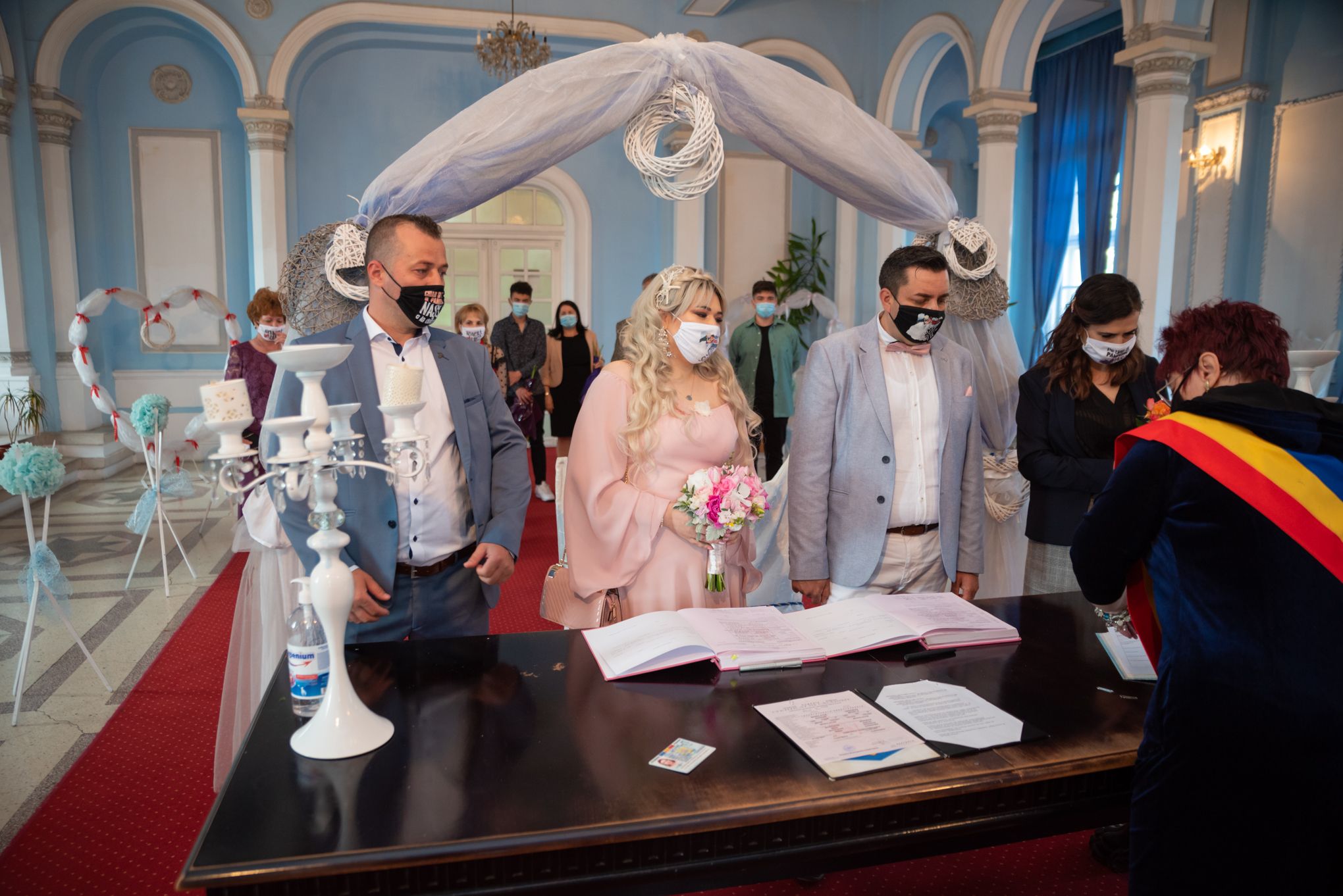 Wedding ceremony in an elegant venue with arched architecture and decorative details.