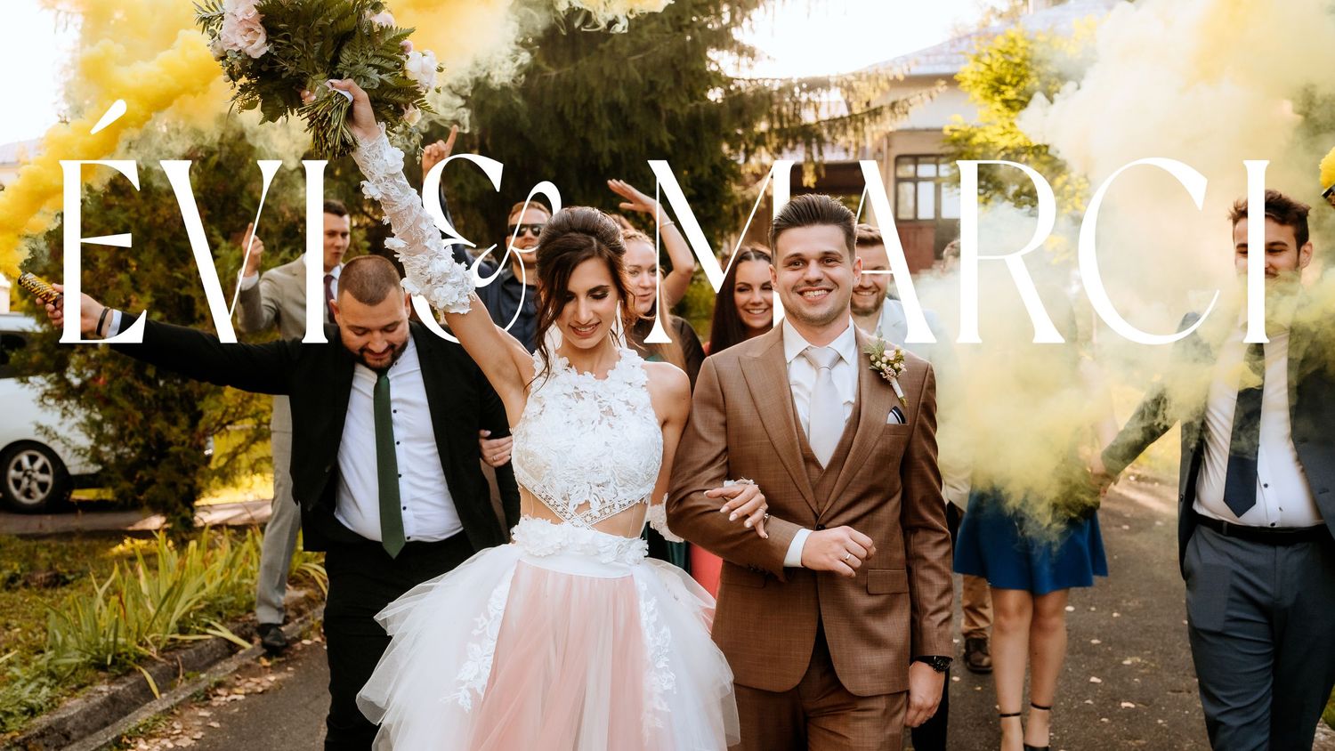 Joyful wedding celebration outdoors with pink tulle dress and brown suit.