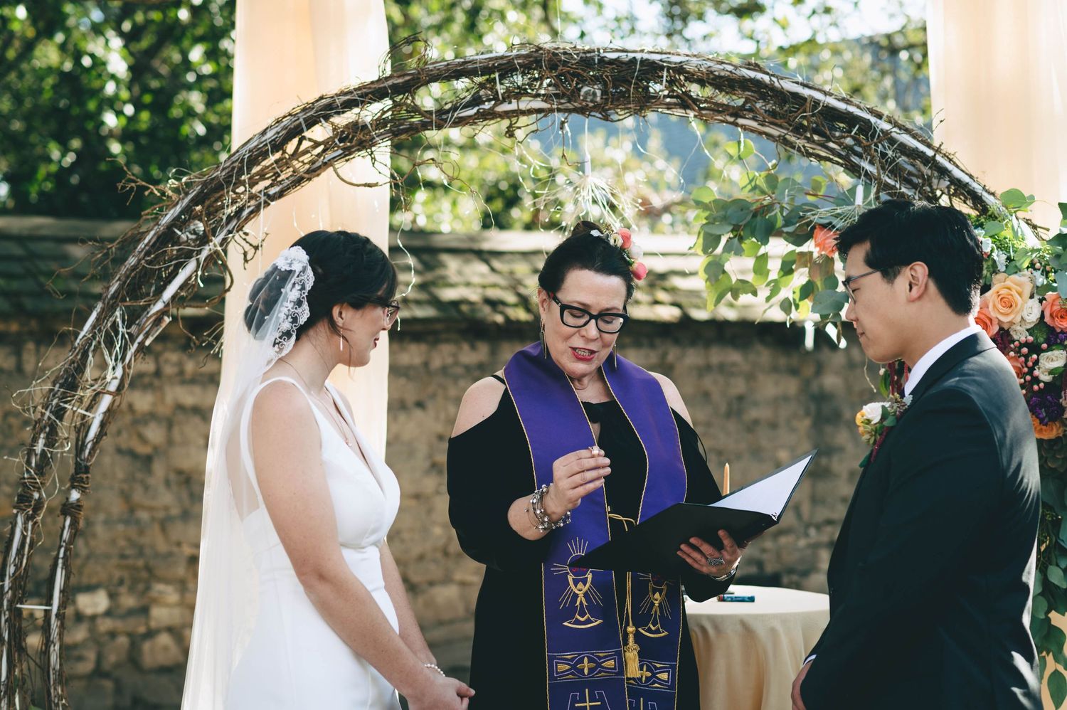 Officiant at the wedding talking about the symbolism of the wedding rings while holding them.