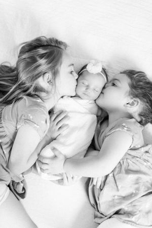 Black and white family portrait showing tender moment taken during a lifestyle newborn session in Springfield, MO.