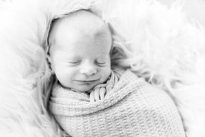 Peaceful newborn portrait in black and white portrait and dreamy lighting taken during a lifestyle newborn session in Springfield, MO.