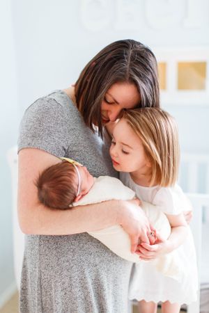 A tender family moment showing affection with a newborn baby in a bright sunlit room during a lifestyle newborn session in Springfield, MO.