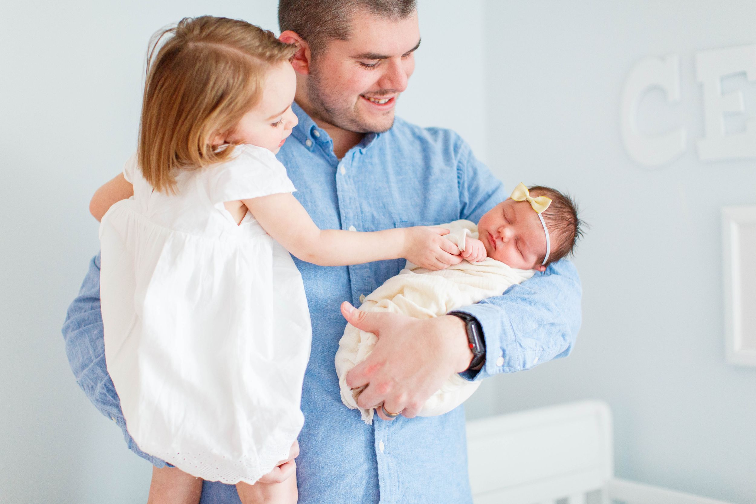A sweet family moment by the window as they admire their newborn baby taken during a lifestyle newborn session in Springfield, MO.