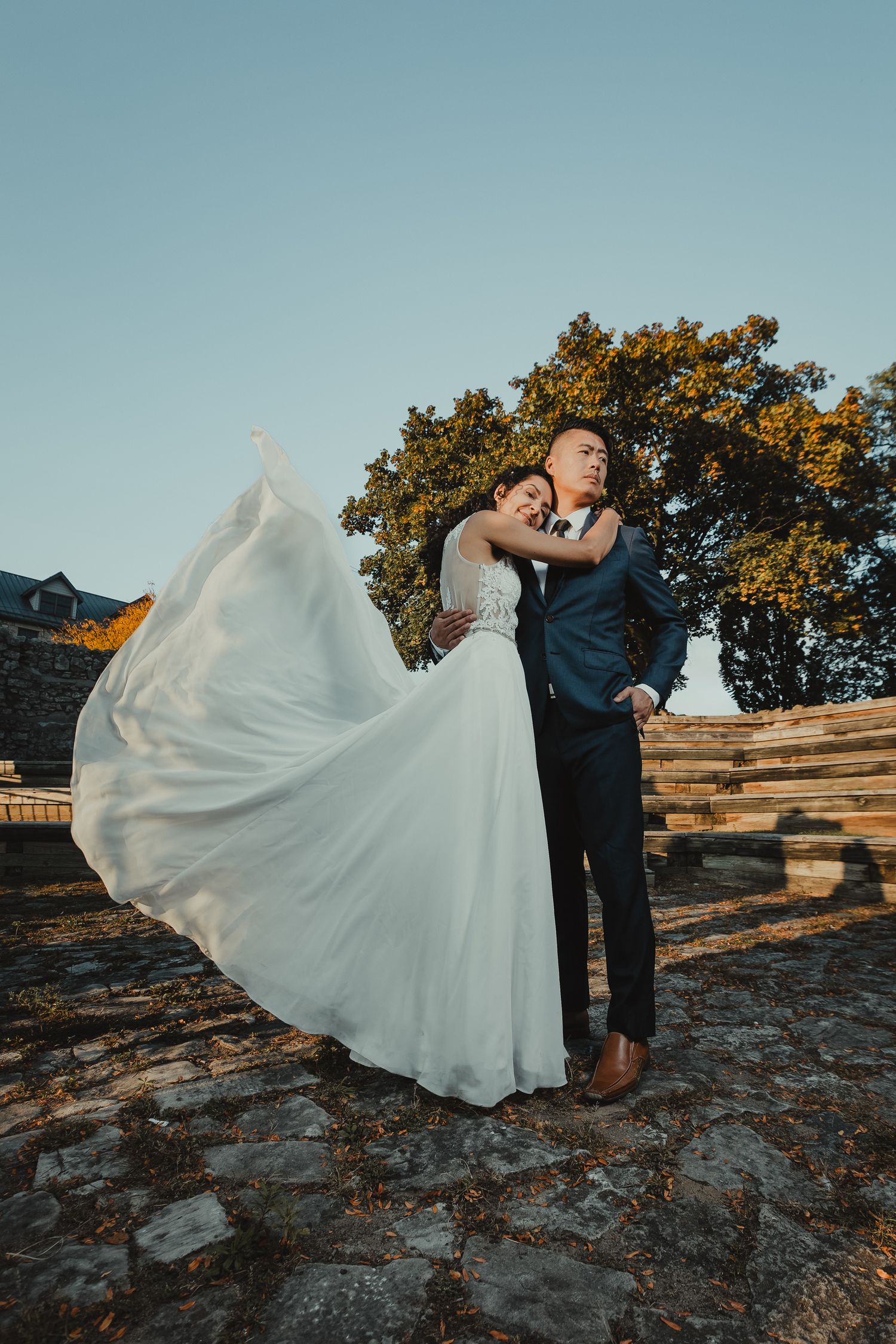 Bride and Groom hugging while wedding dress is flowing