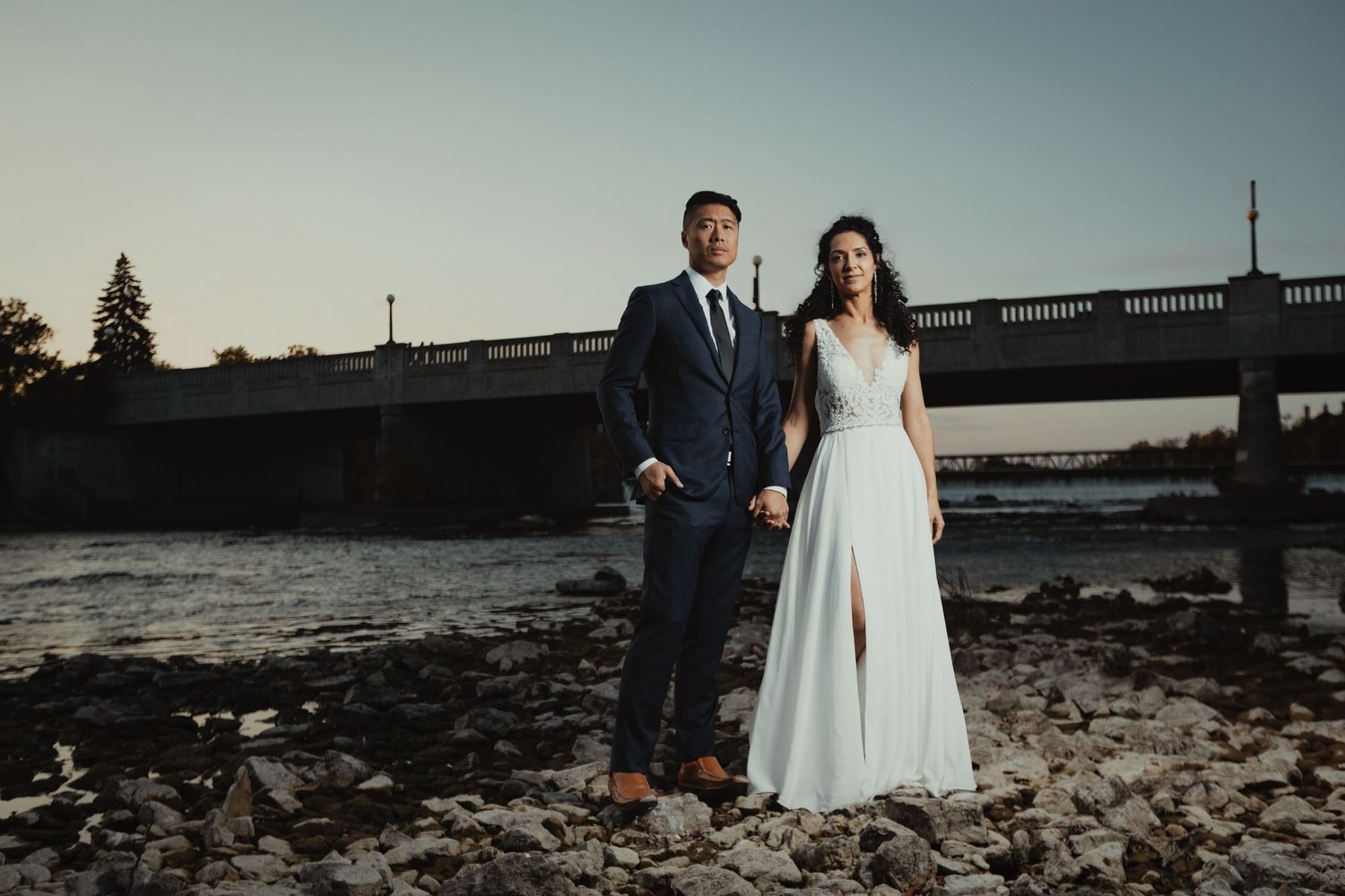 Bride and Groom beside a lake and looking at the camera pose