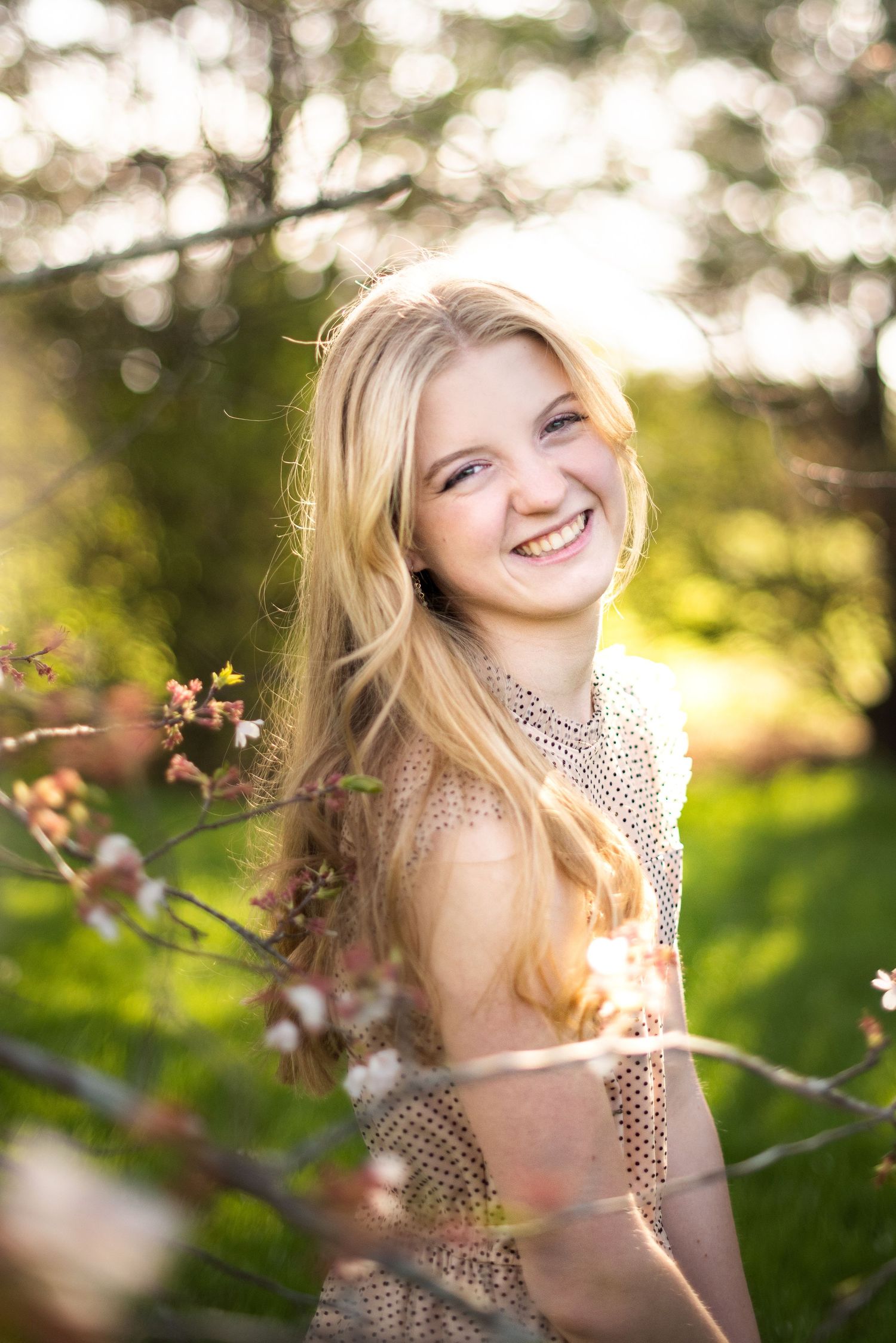 Portrait in golden sunlight with blooming spring flowers in background.
