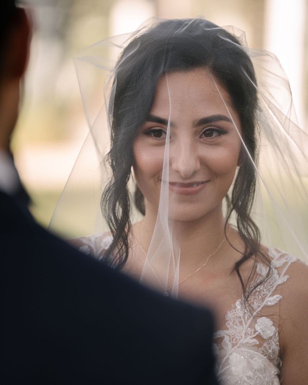 An elegant bride in a lace wedding dress with a delicate veil.