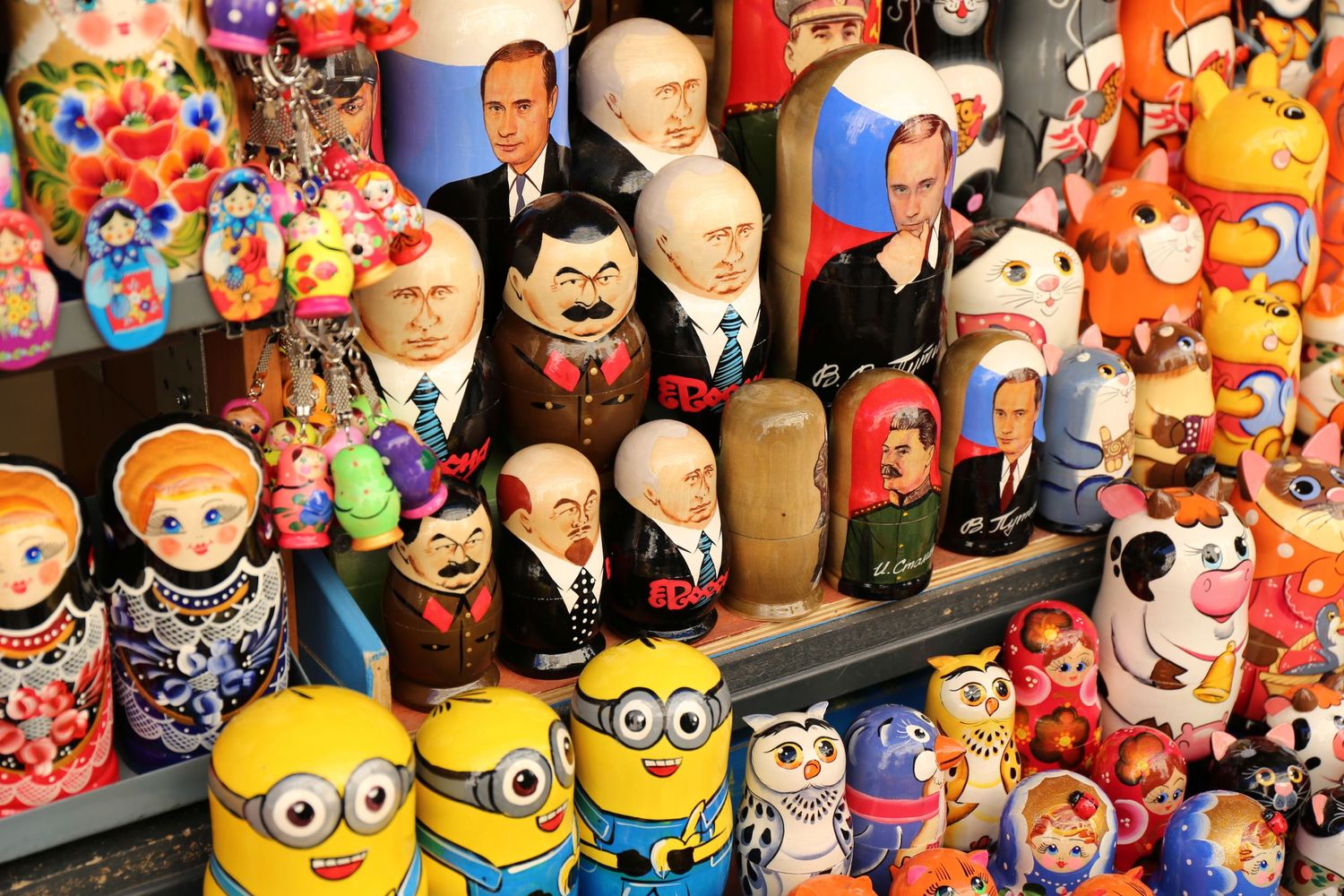 Colorful display of decorative matryoshka dolls and cartoon character figurines for sale.