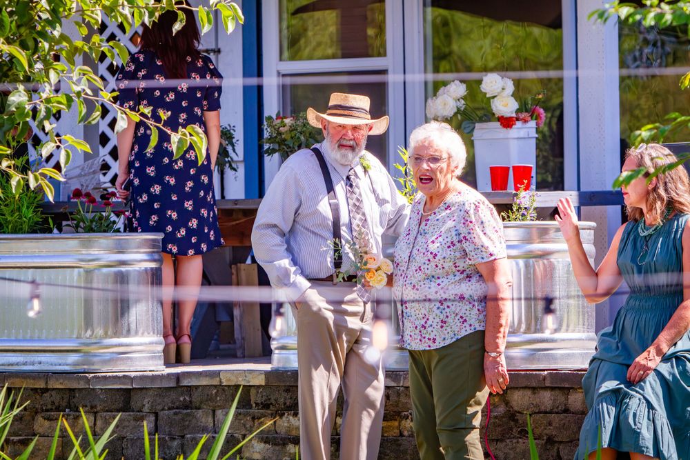 People gather outside a building with American flags and decorative bunting for a patriotic celebration.