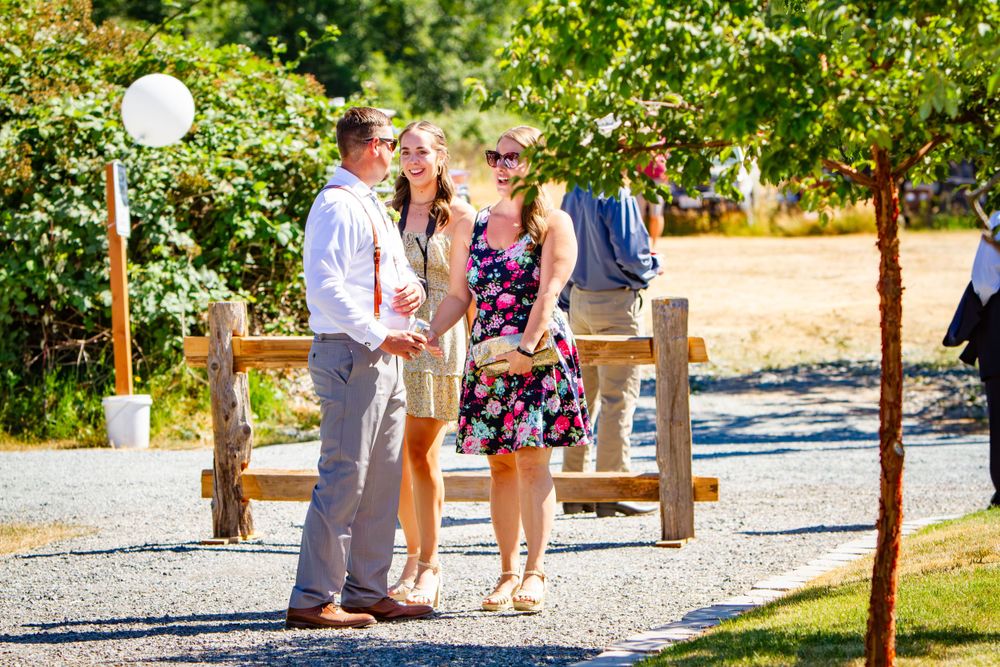Wedding ceremony taking place outdoors in a garden setting with white chairs and natural decor.