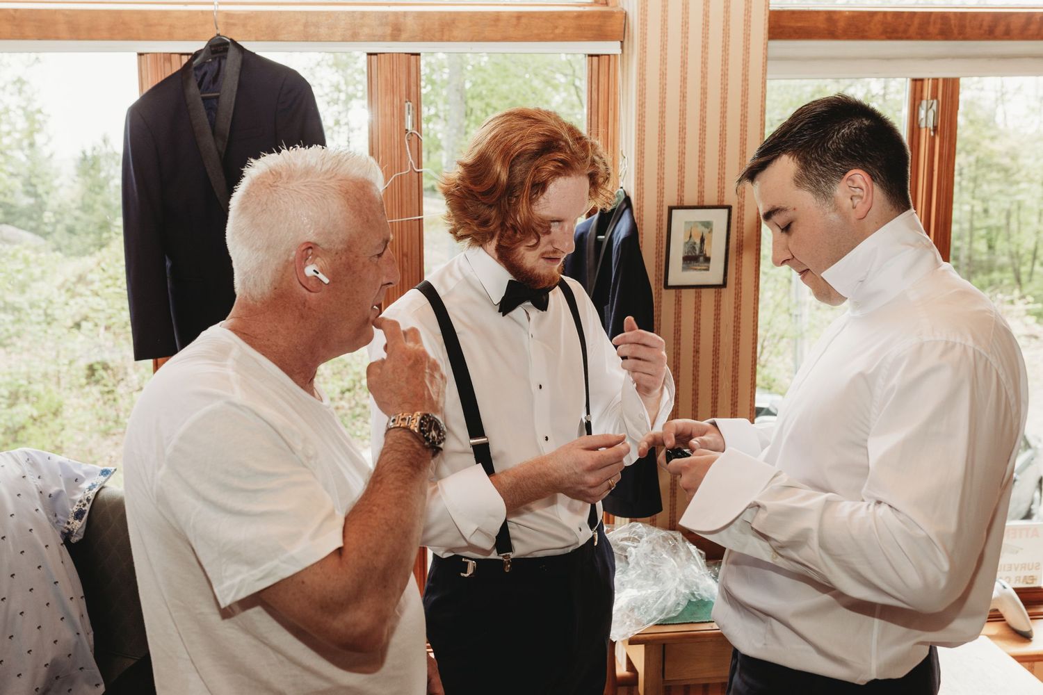 Three people get ready before a formal event as they adjust their attire in a sunlit room.