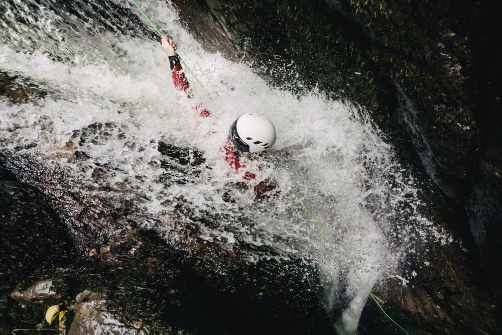 My Adventure guide abseils through heavy waterfall flow