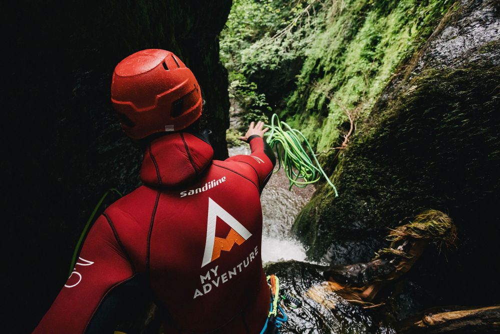 My Adventure canyoning guide throws rope off waterfall