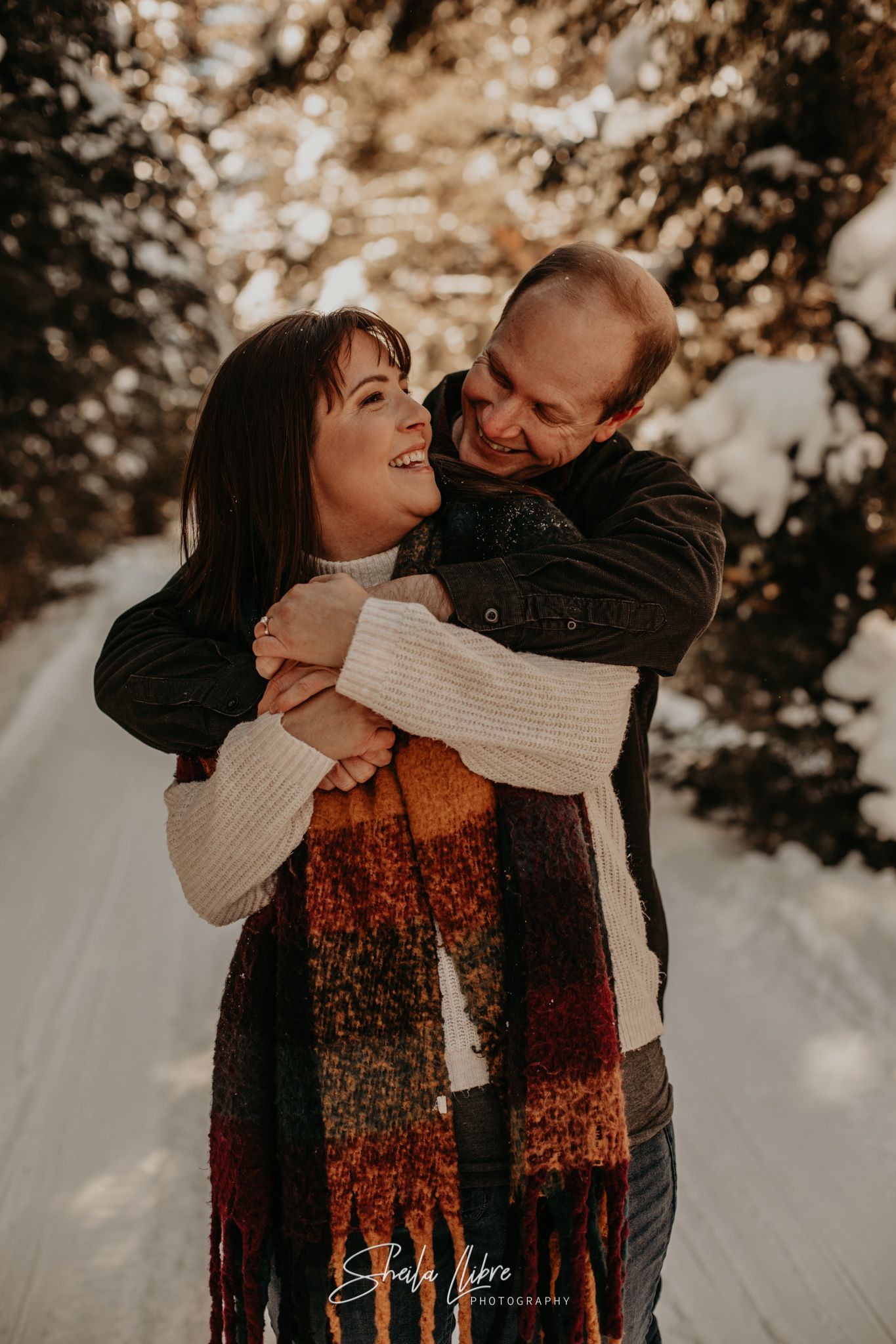 A sweet embrace captured during a winter couples photoshoot in the forest.