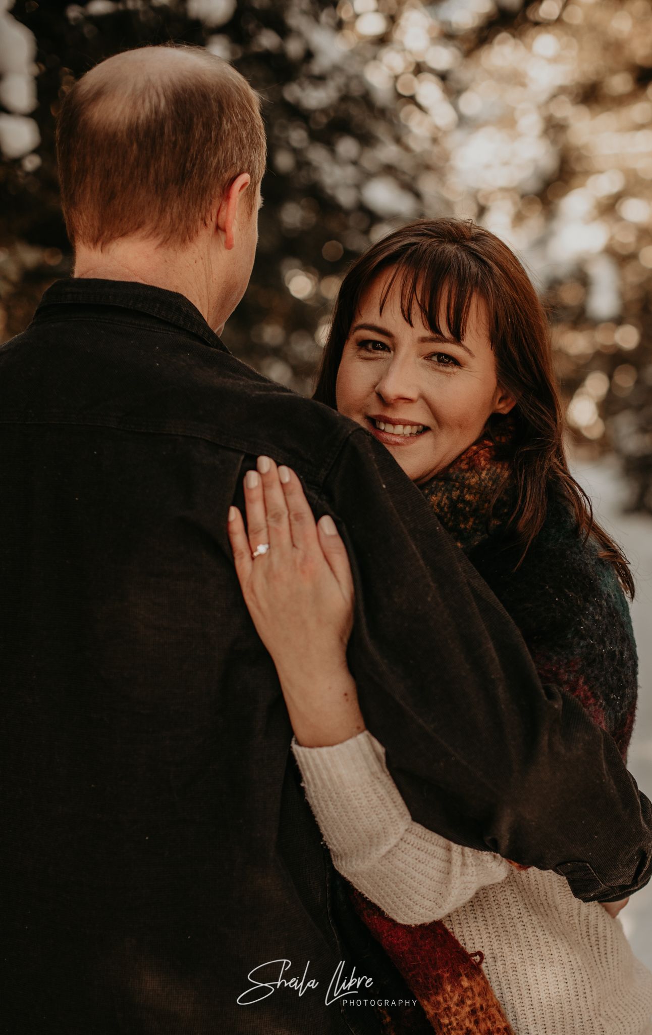 Intimate engagement portrait showing affectionate couple in winter clothing.