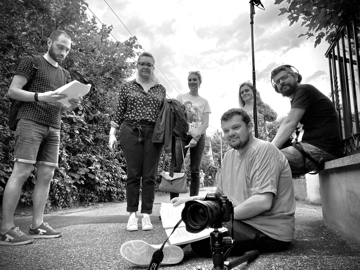 Black and white photo of a small group gathered outdoors with a dog.
