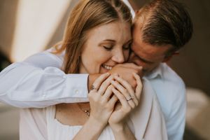 Candid engagement photo capturing laughter and joy in natural light.