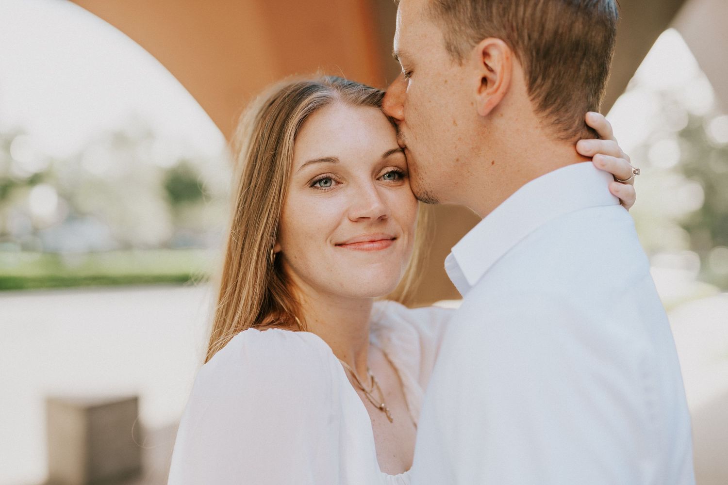 An intimate couple's portrait showing tender affection in warm sunlight.