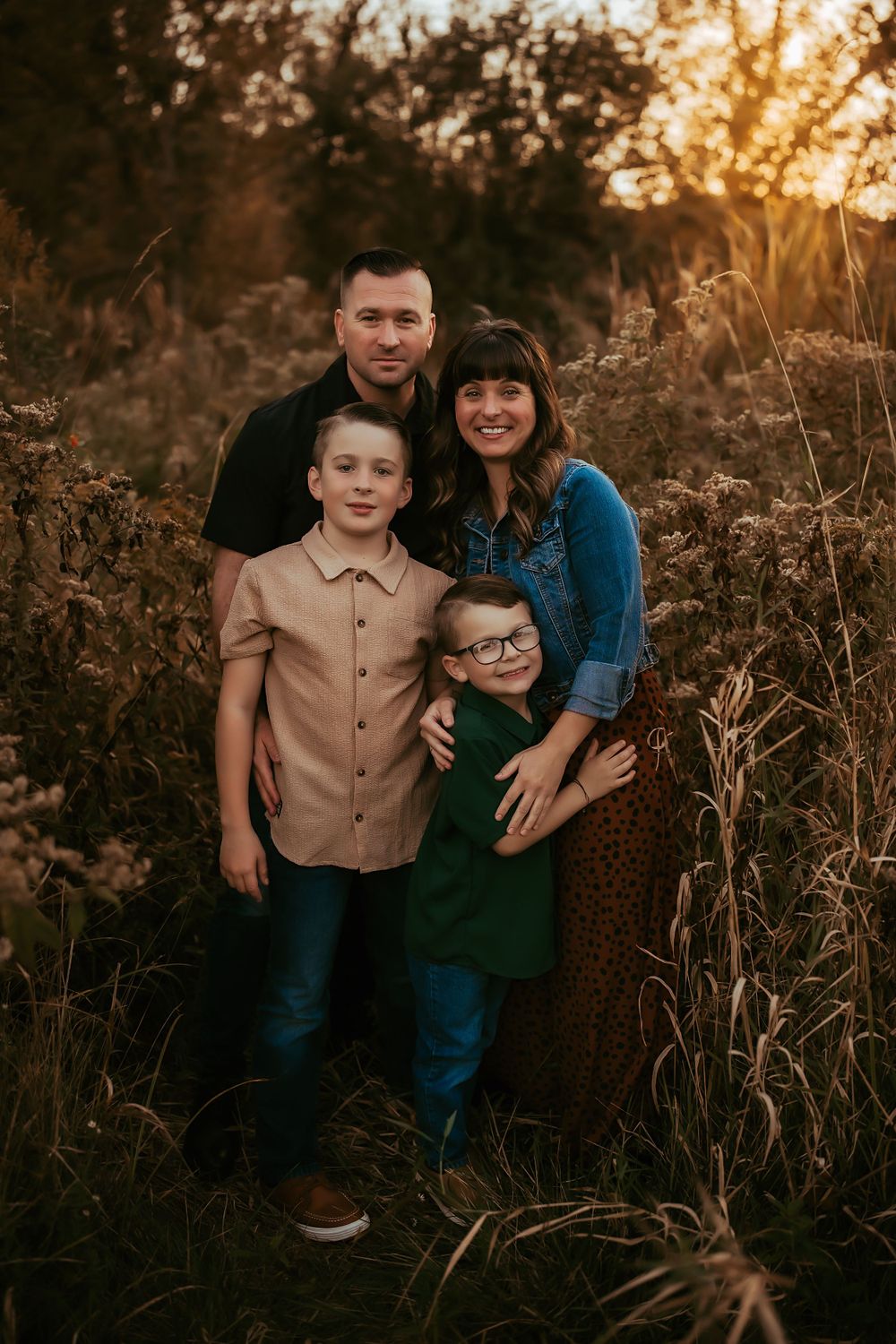 Mother, father, and two sons cuddled in close.