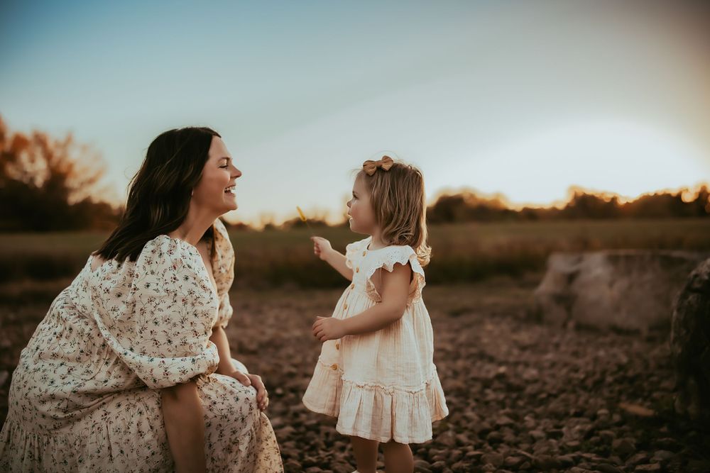 Motherhood at golden hour. Sweet moment between mother and young daughter.