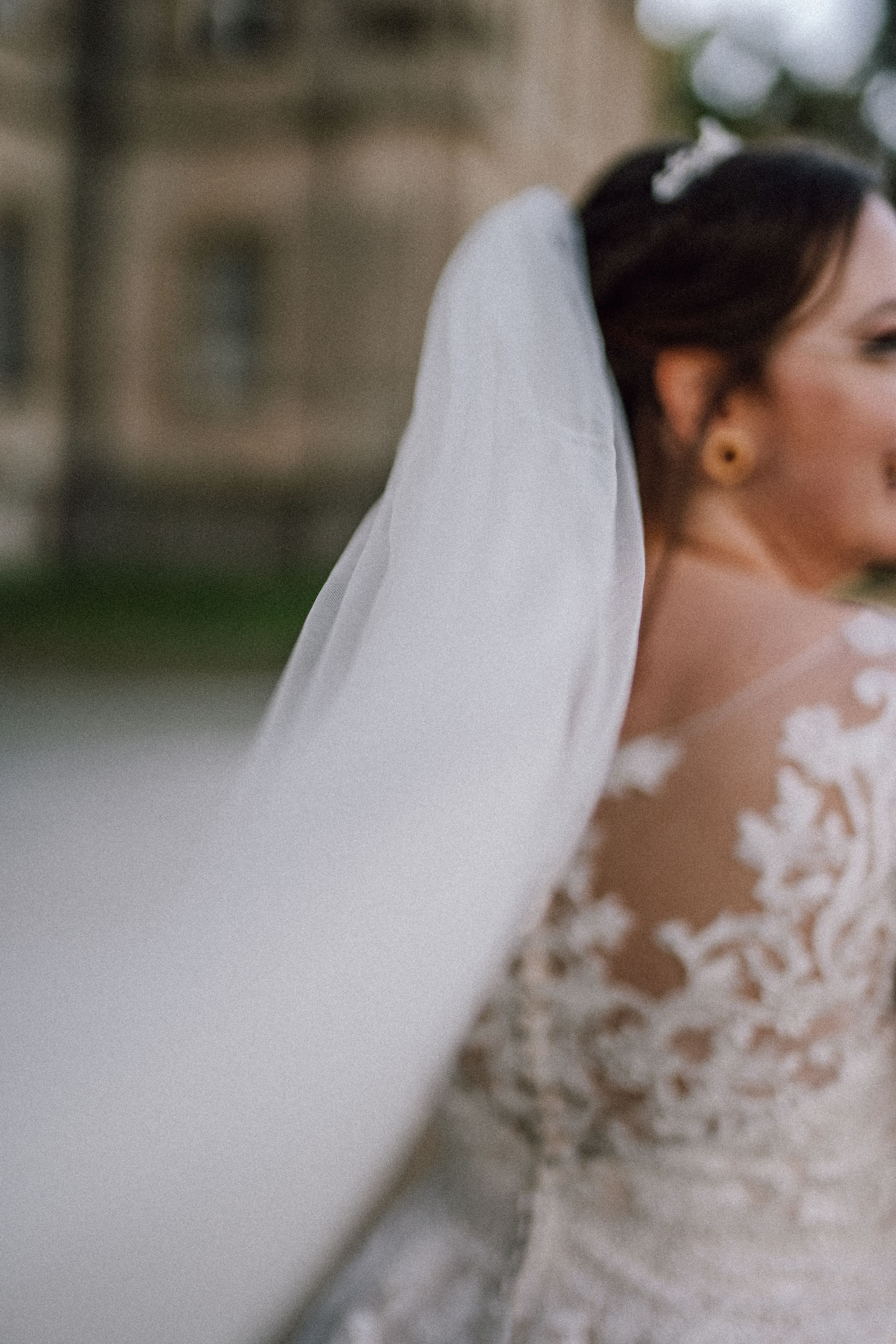 Close-up detail of delicate lace and veil on a wedding dress.