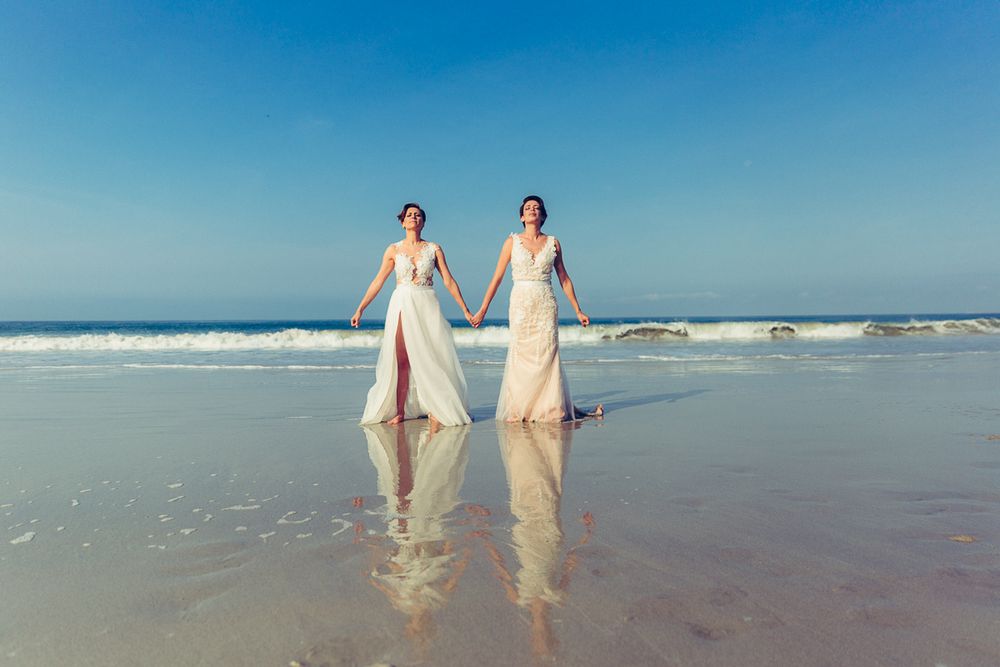 Full length beach wedding photo with perfect reflections in wet sand.
