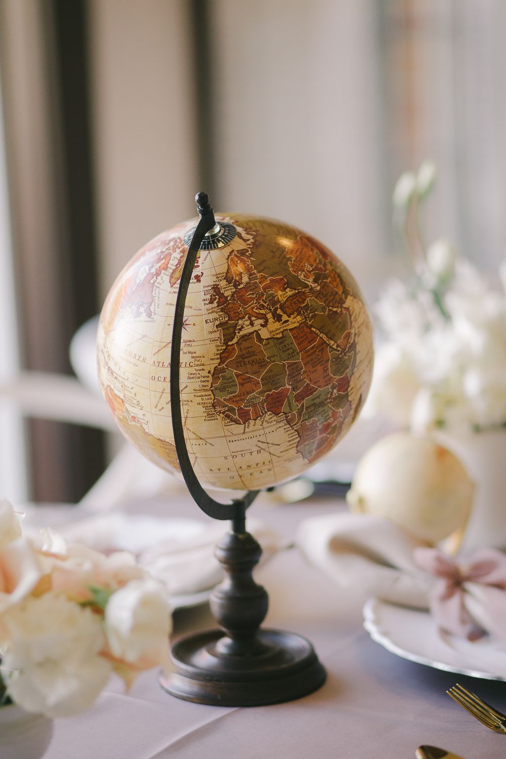 a detail view of a vintage earth globe in neutral tones photographed by Paula Ortiz NY Family Photographer