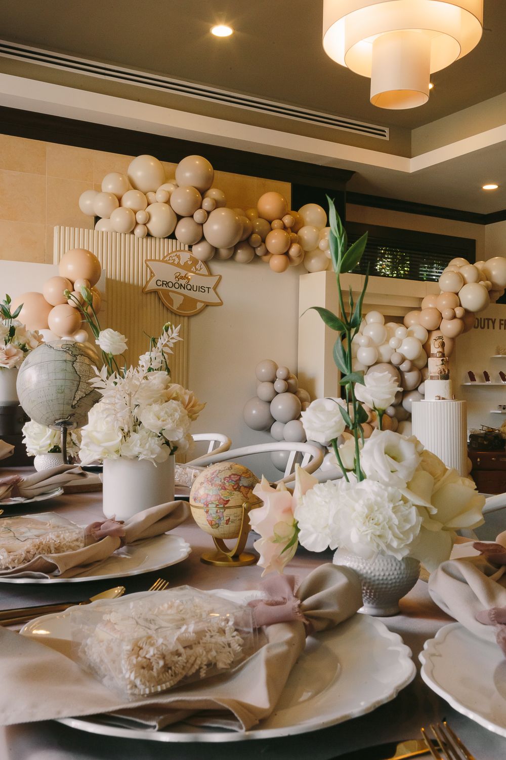 a lateral view of a baby shower decor in brown and beige with a journey theme, balloons and flowers photo by Paula Ortiz