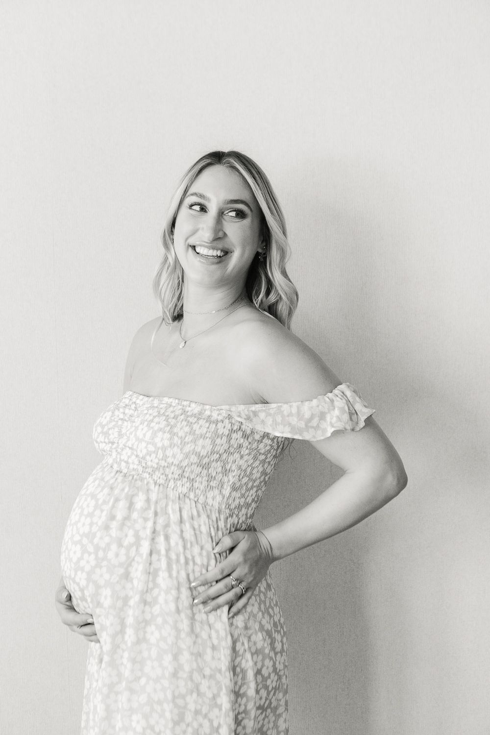 a black and white half body view of a pregnant woman smiling during her baby shower in Verona NJ captured by Paula Ortiz