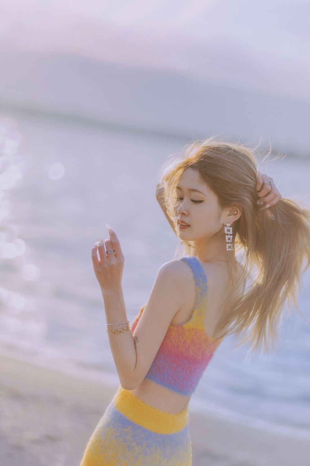 A sunset beach portrait featuring a colorful striped dress catching the golden hour light.
