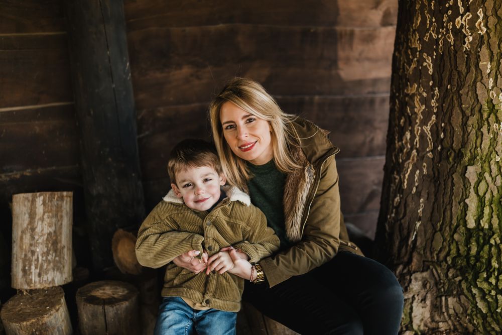 Cozy portrait session against rustic wooden cabin wall.
