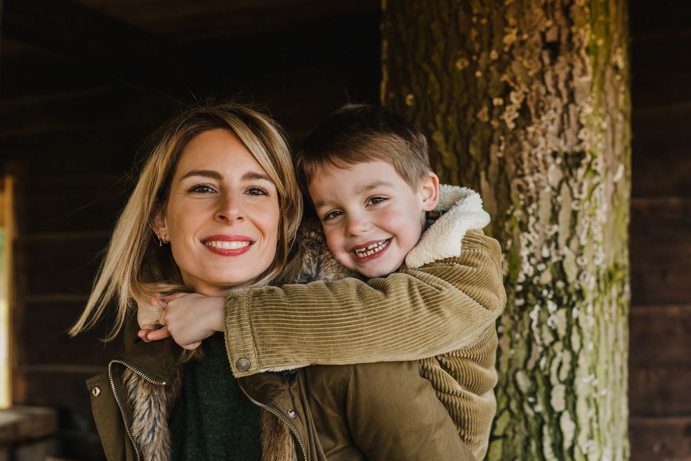 A playful embrace captured in natural light against a rustic wooden backdrop.