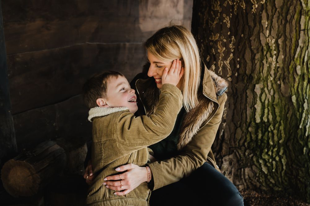 A joyful candid moment between parent and child in matching brown jackets.
