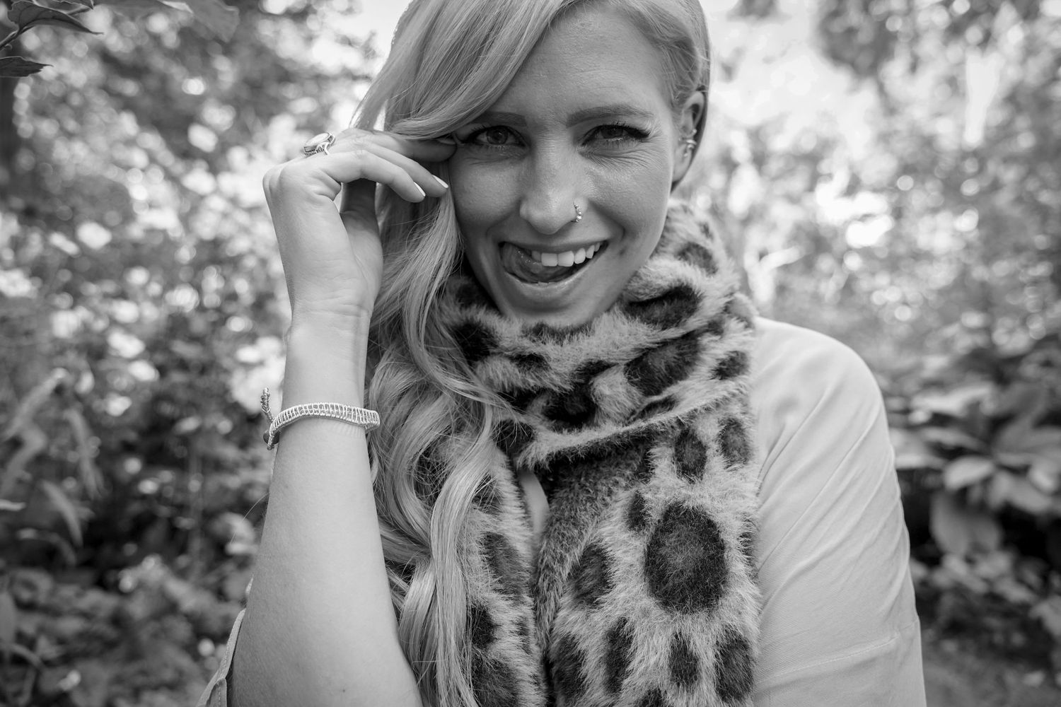 Black and white portrait with leopard print scarf in natural setting.