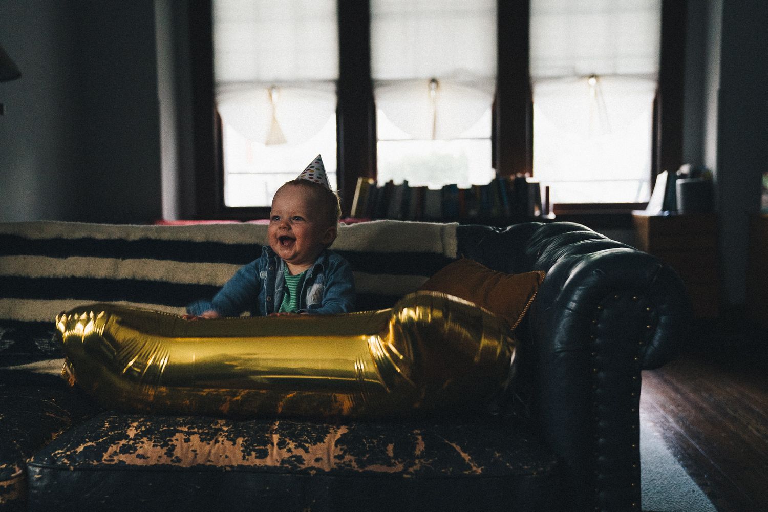 Child playing near decorative gold piece in dimly lit interior.