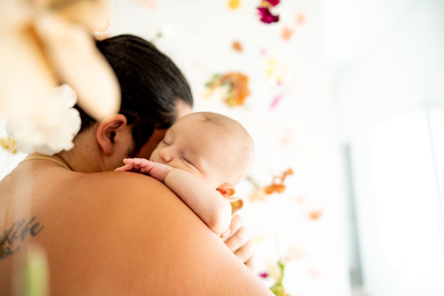 Baby resting peacefully against parent's shoulder in intimate bonding moment.
