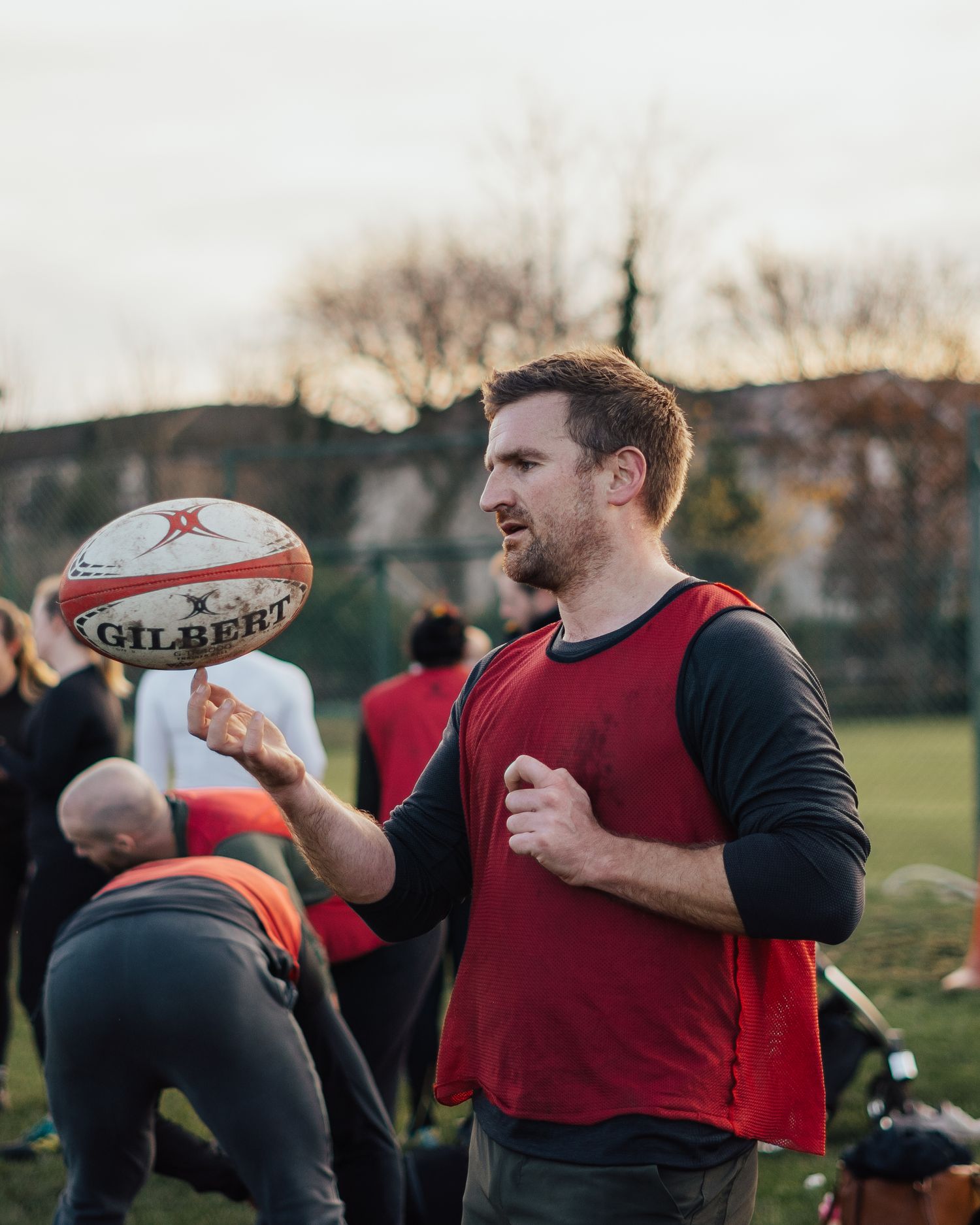 A rugby player practicing ball handling drills during an outdoor training session.