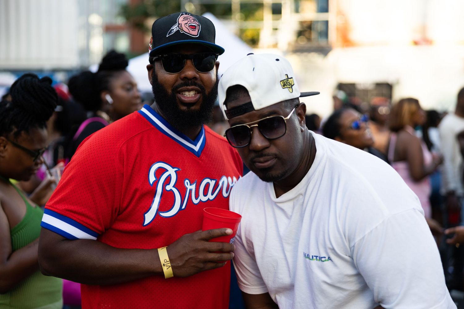 Two friends enjoying a gathering wearing baseball-themed attire.