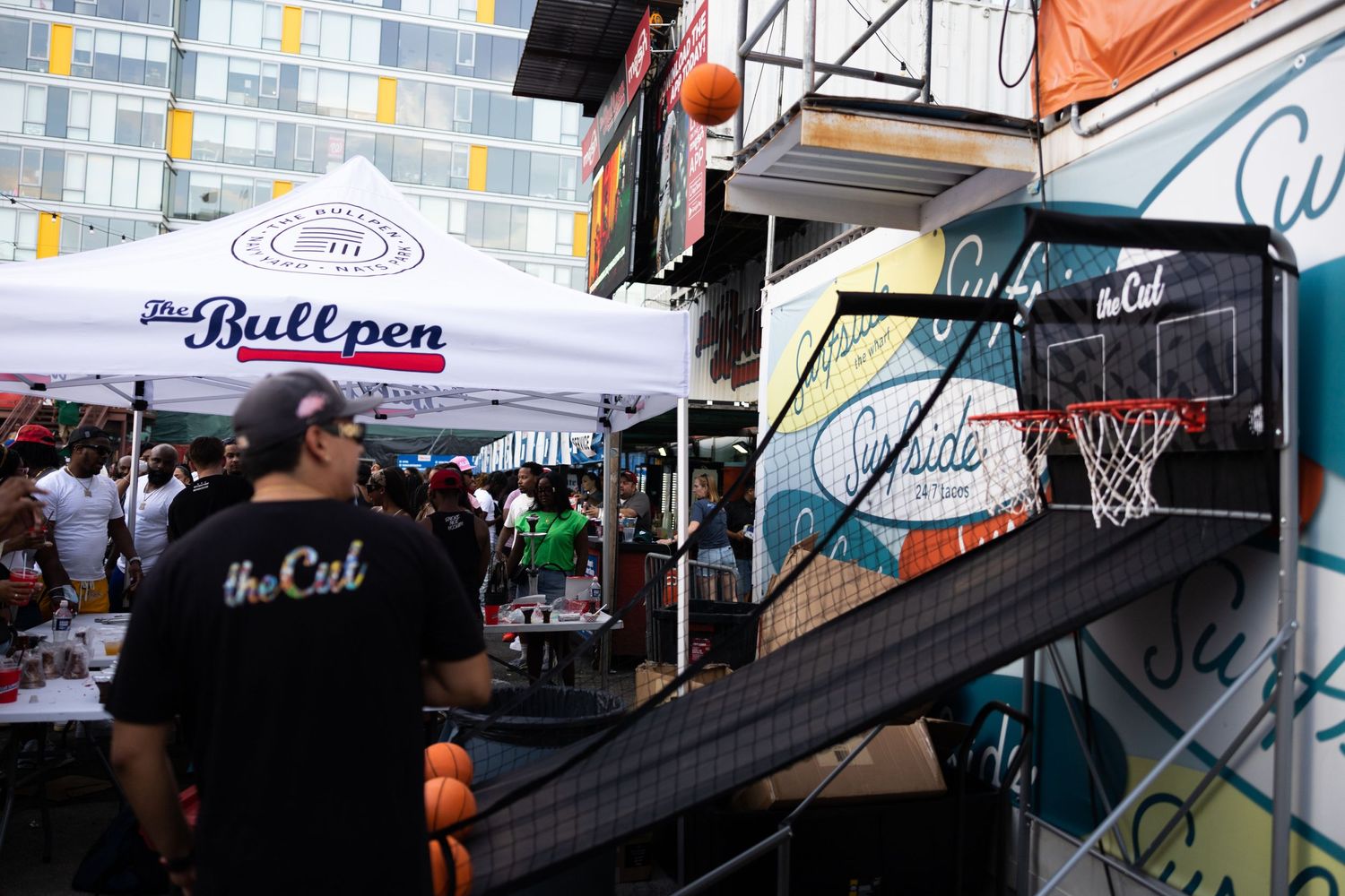 A street vendor serving refreshments under branded umbrellas at an outdoor event.