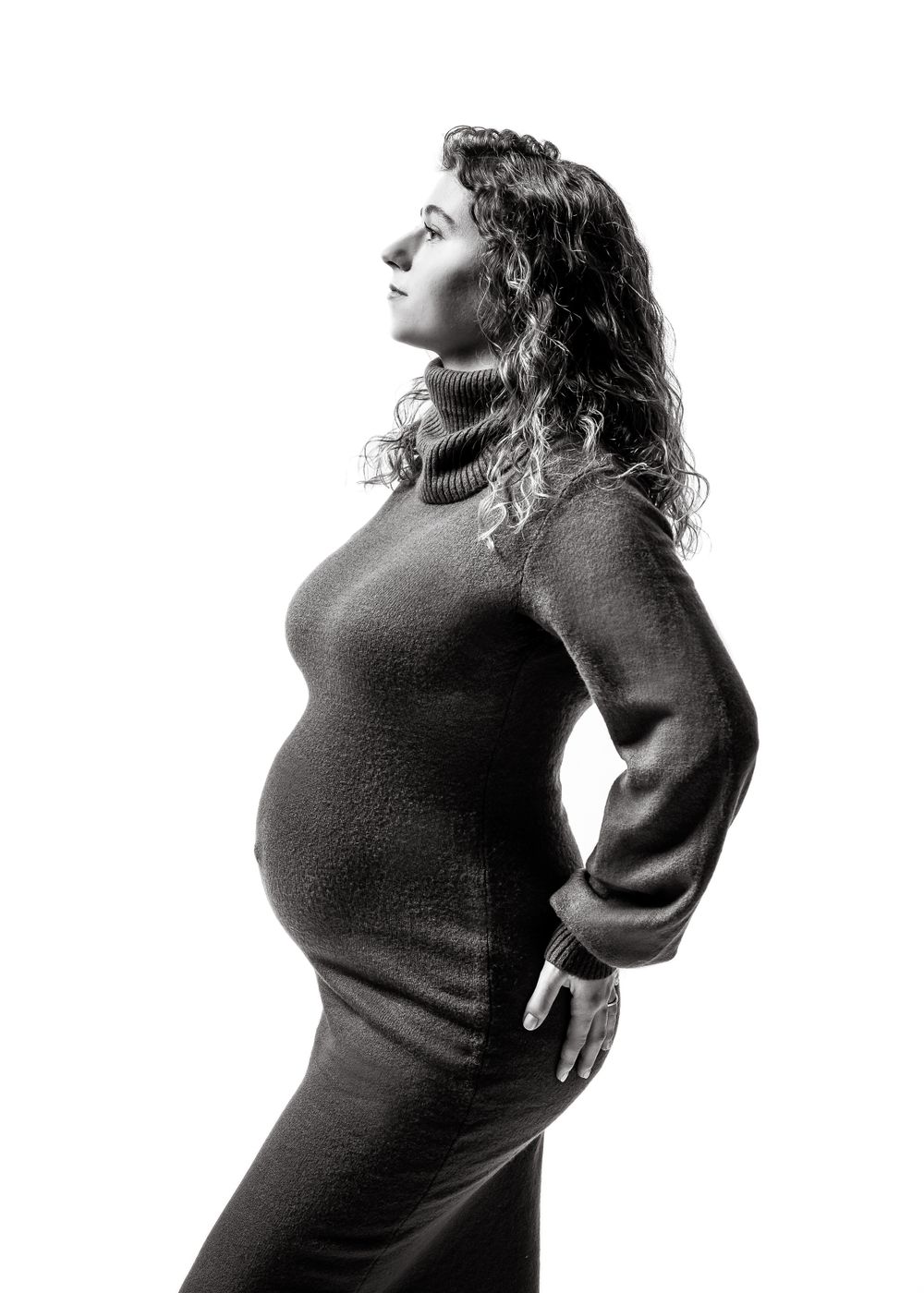 Side profile maternity silhouette in black and white featuring woman in turtleneck sweater.
